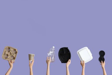 Leylak arka planında farklı çöpleri tutan kadın eller. Geri dönüşüm kavramı