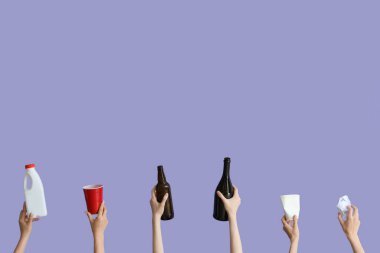 Leylak arka planında farklı çöpleri tutan kadın eller. Geri dönüşüm kavramı