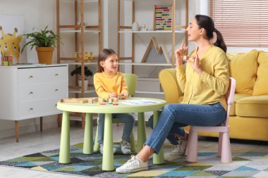 Ofiste L harfini telaffuz eden küçük tatlı bir kızı olan kadın konuşma terapisti.