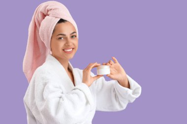 Mor arka planda bornozlu güzel, genç, mutlu bir kadın.