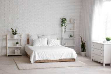 Rahat yatağı ve raf üniteleri olan modern yatak odası.