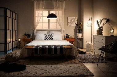 Güzel, modern yatak odasının içi. Büyük yataklı, parlak lambalı.