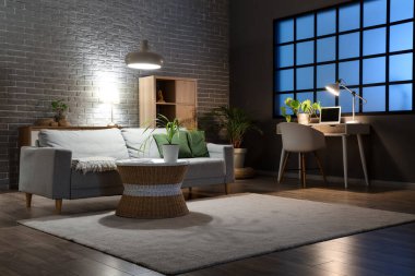 Rahat kanepesi, masaları ve parlak lambaları olan oturma odasının içinde.