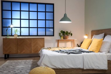 Yatak odasının içi, rahat yatak odası, çekmeceler ve parlayan lambalar.