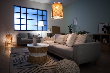 Kanepeleri, masası ve parlayan lambaları olan rahat bir oturma odası.