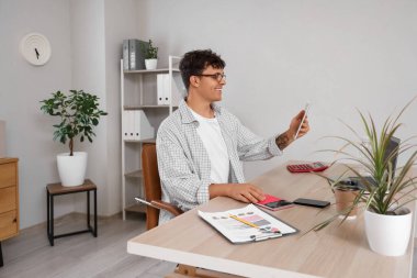 İş yerinde gözlüklü, tablet kullanan, modern bilgisayarlı bir erkek muhasebeci.