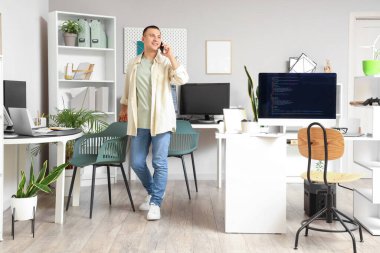 Ofiste cep telefonuyla konuşan yakışıklı programcı