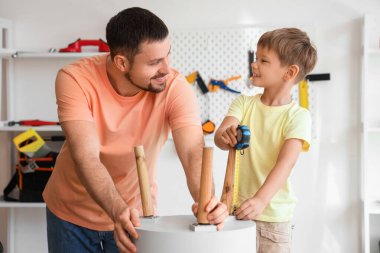 Mutlu baba ve farklı enstrümanlarla evde kahve masası kuran küçük oğlu.