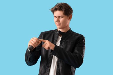 Mavi arka planda feneri olan genç bir adam.