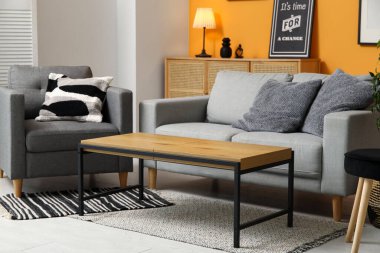 Oturma odasının iç tarafında rahat bir kanepe, koltuk ve sehpa.