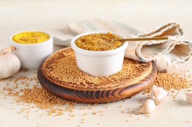 Beyaz arka planda tohumlu ve sarımsaklı bir kase Dijon hardalı.