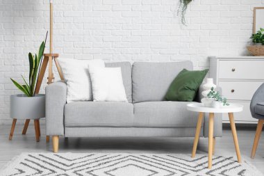 Gri kanepesi ve masası olan oturma odasının içinde.