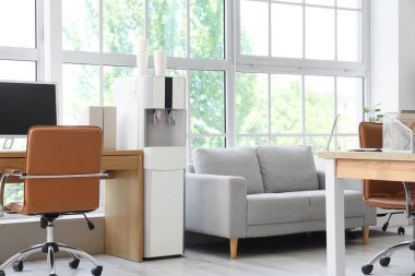 Su soğutucusu, çalışma yeri ve kanepesi olan ışık ofisinin içinde.