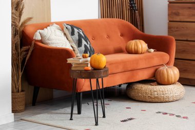 Rahat kanepe, balkabağı, sehpa ve çekmeceler sonbaharda oturma odasının iç kısmında.