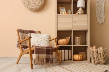 Koltuk ve raf, oturma odasının içindeki bej duvarın yanında.