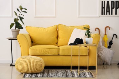 Konforlu kanepe, puf, sehpa ve şemsiyeler koridorun iç tarafında.