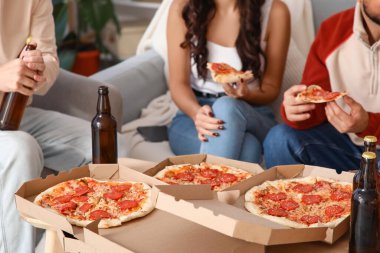 Evde biberli pizza yiyen arkadaşlar, yakın plan.