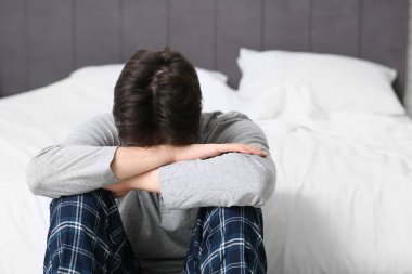 Depresyondaki genç adam yatak odasında