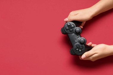 Kırmızı arka planda modern joystickli kadın elleri