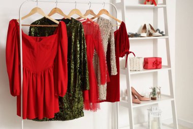 Raflı elbise askısı ve soyunma odasındaki beyaz duvarın yanında Noel hediyesi kutuları.