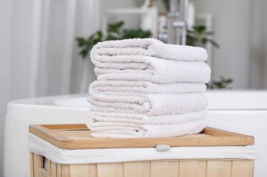 Banyodaki çamaşır sepetine katlanmış temiz havlu yığını.