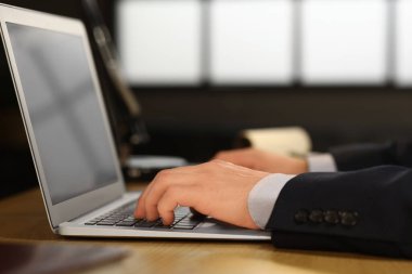 Genç iş adamı geceleri ofiste dizüstü bilgisayarla çalışıyor.