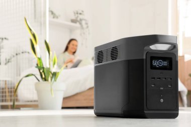 Portatif elektrik santrali, yatak odasında dergi okuyan kadınlara karşı, yakın çekim.