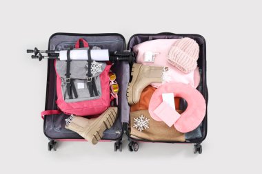 Sırt çantalı bavulu aç ve arka planda kış aksesuarları, üst görünüm