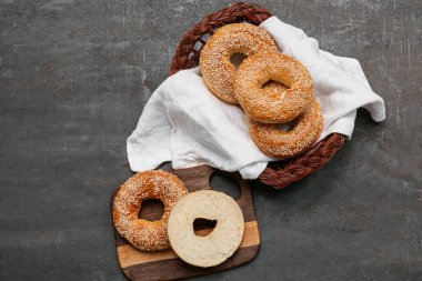 Tahta tahta ve siyah arka planda susam tohumlu lezzetli simit sepeti.
