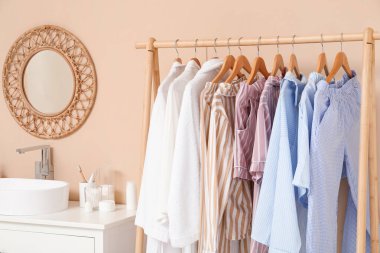 Giysilerle, çekmecelerle ve odada bej duvarın yanında lavaboyla