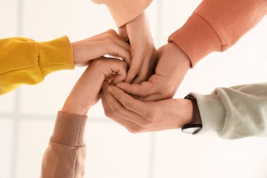 Bir grup insan el ele tutuşuyor.