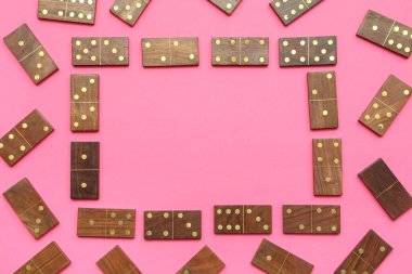 Pembe arka planda tahta domino taşlarından yapılmış çerçeve