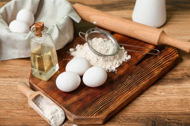 Tahtayı un, taze yumurta, yağ ve ahşap masada hamur hazırlamak için kap kacak.