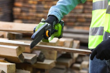 Erkek marangoz kereste fabrikasında kereste kesiyor, yakın plan.