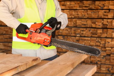 Testereli erkek marangoz kereste fabrikasında çalışıyor, yakın plan.