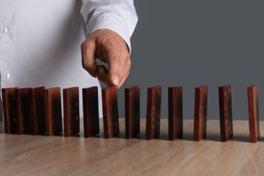 Masasında tahta domino taşları olan bir adam. Yönetim kavramı