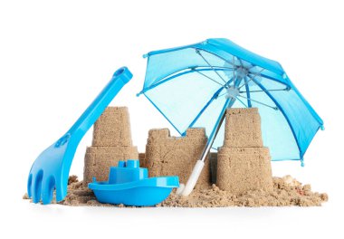 Beyaz arka planda kumdan kale, plaj oyuncakları ve küçük şemsiye