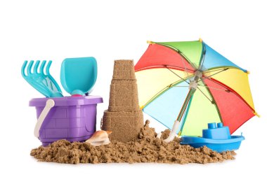 Beyaz arka planda kumdan kale, plaj oyuncakları ve küçük şemsiye