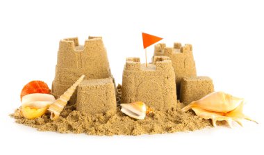 Beyaz arka planda deniz kabukları olan kumdan kale