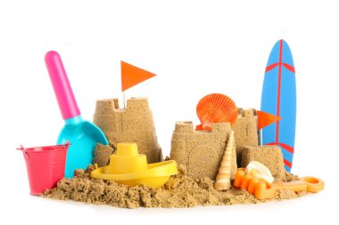 Beyaz arka planda kumdan, plaj oyuncaklarından ve mini sörf tahtasından kale