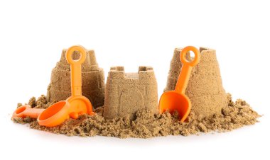 Beyaz arka planda kumdan yapılmış kumsal oyuncakları olan kale.