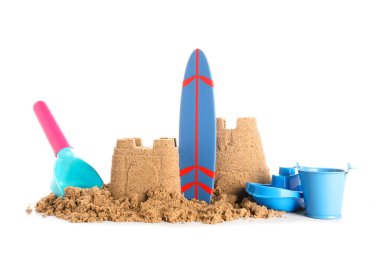 Beyaz arka planda kumdan kale, mini şezlong ve plaj oyuncakları.