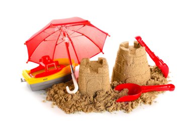 Beyaz arka planda kumdan kale, plaj oyuncakları ve küçük şemsiye