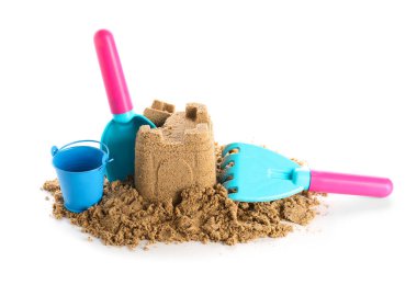 Beyaz arka planda kumdan ve plaj oyuncaklarından kale