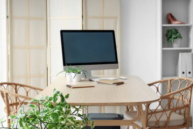 Boş bilgisayar monitörü ve giyim mağazası ofisindeki masanın üzerindeki not defterleri olan işyeri