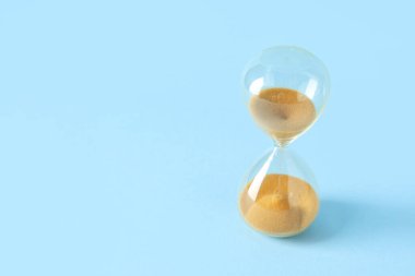 Mavi zemin üzerinde sarı kum bulunan şık kum saati