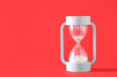 Kırmızı zemin üzerinde beyaz kum bulunan şık kum saati