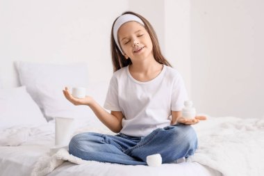 Evdeki yatağında krema dolu kavanozları olan tatlı, mutlu bir kız.