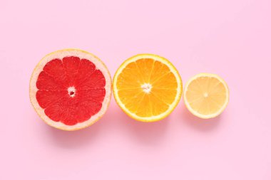 Pembe arka planda farklı kesilmiş turunçgil meyveleri