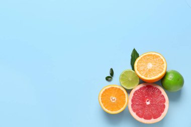 Farklı kesilmiş turunçgiller ve mavi arka planda yapraklar